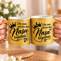 Set cadou pentru nași format din două căni glitter aurii, cu mesaje Nașu’ bogătașu’ și Nașa bogătașa